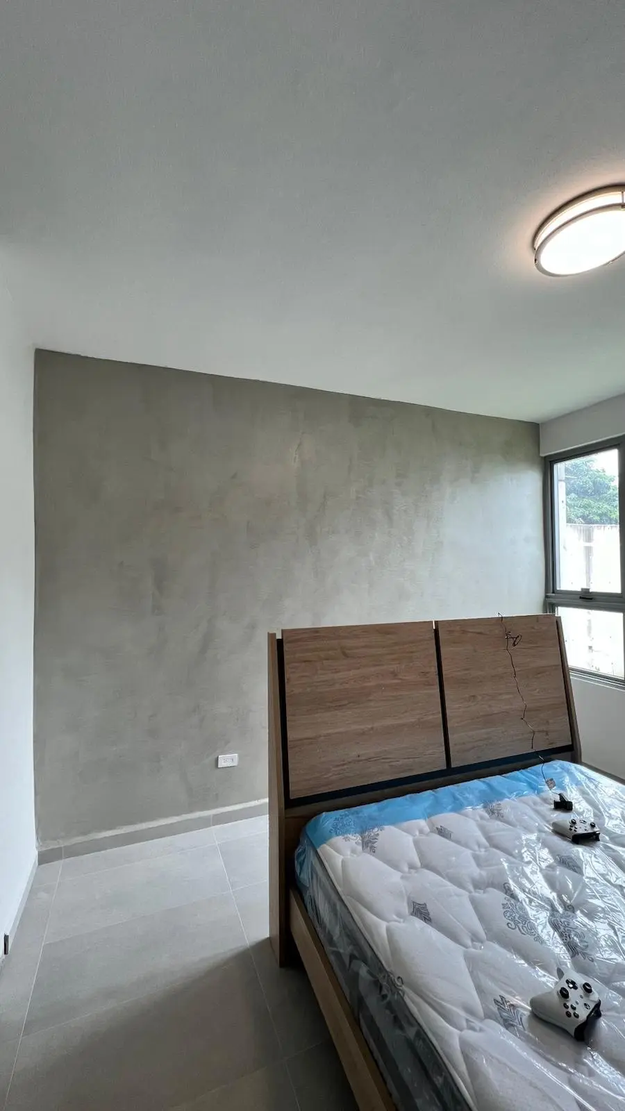 Dormitorio con pared focal en cemento pulido