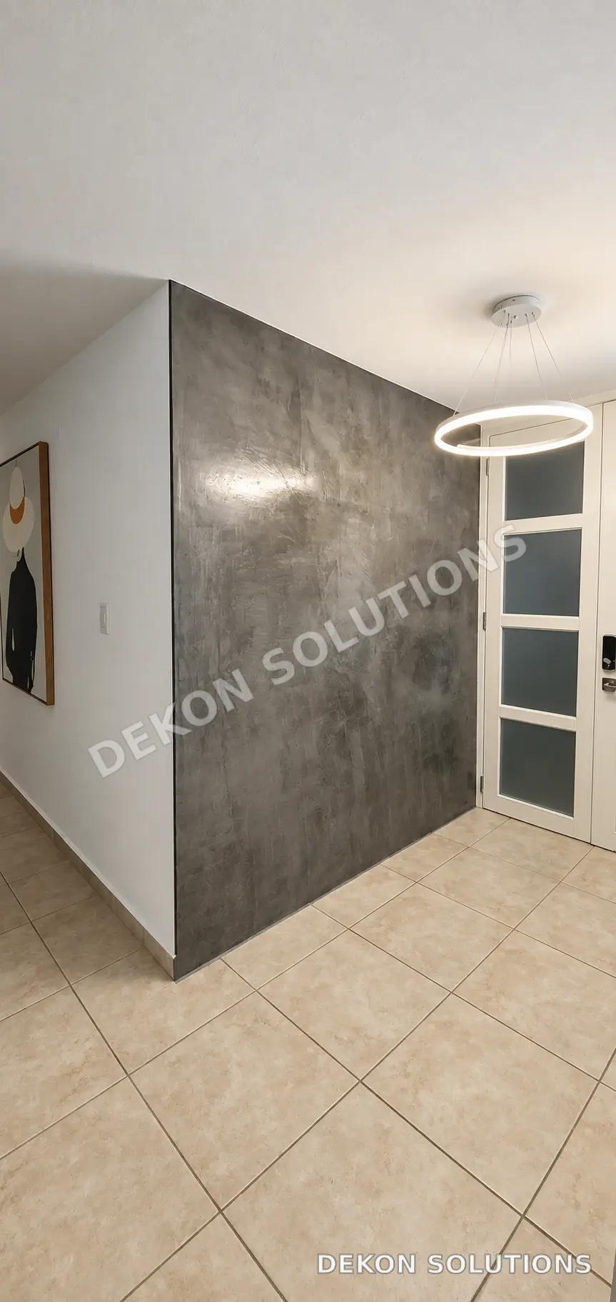 Entrada interior con pared envolvente en cemento pulido grafito
