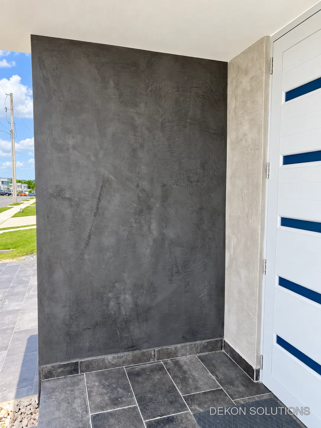 Entrada residencial con pared en cemento pulido grafito