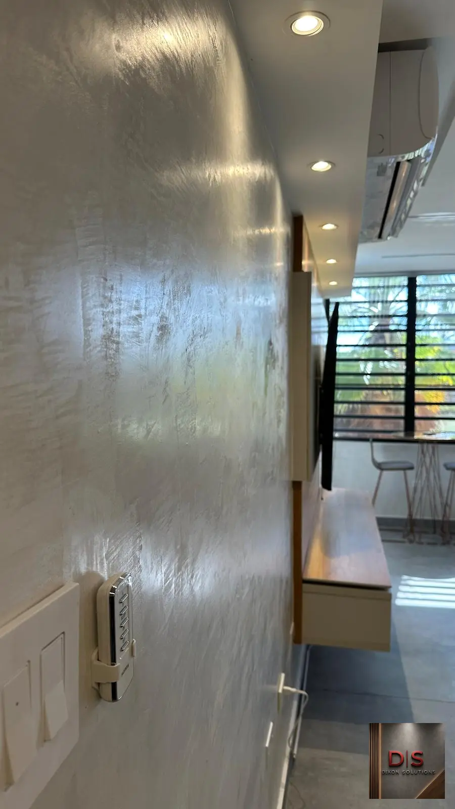 Detalle de pared interior en cemento pulido bajo iluminación empotrada